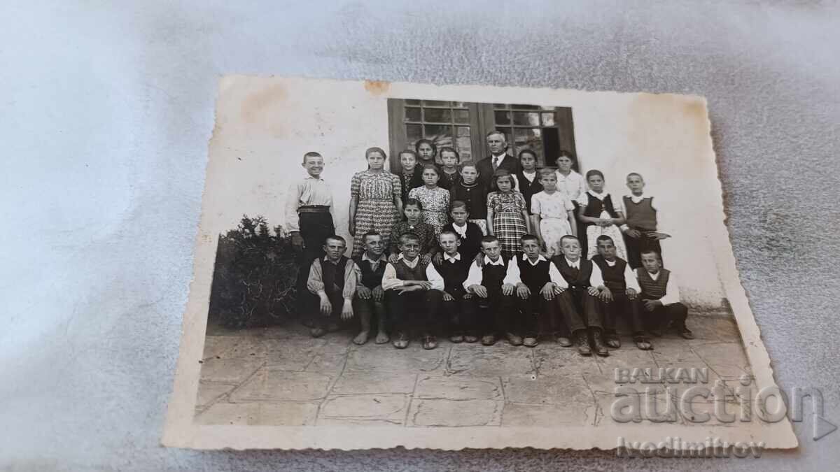 Photo of 4th Grade Students with their Teacher in front of the School