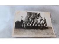 Fotografie Elevi din clasa a IV-a cu învățătorul lor în fața școlii