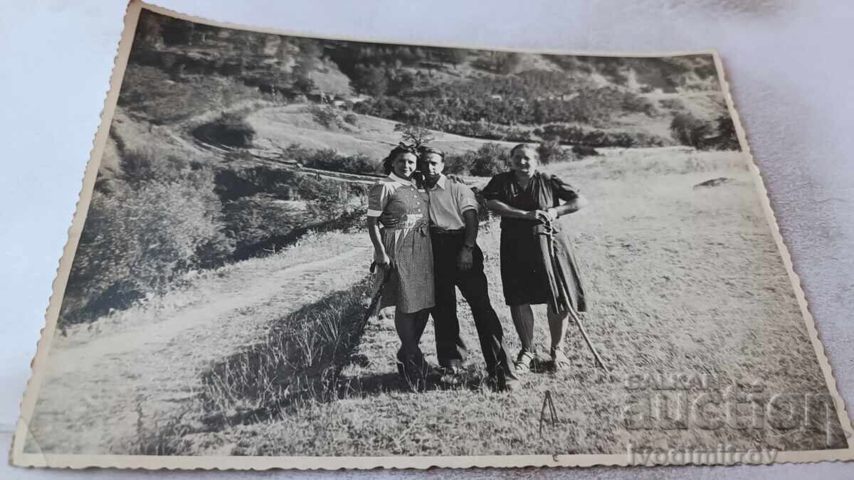 Photo: Man and Two Women Above the Village