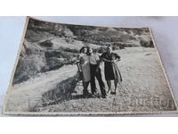 Photo: Man and Two Women Above the Village