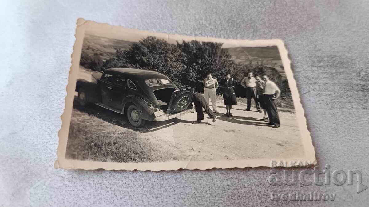 Photo of a man and a woman with a retro car with license plate Pl 801