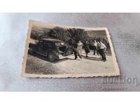 Fotografie Bărbați și femeie cu autoturism retro cu nr. de înmatriculare Pl 801