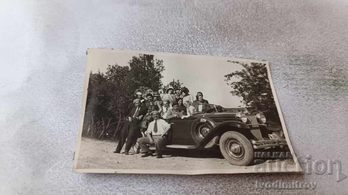 Photo of men and women with a retro car with license plate TV 256