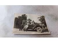 Fotografie Bărbați și femei cu autoturism retro cu nr. de înmatriculare Tv 256