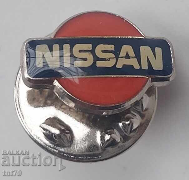 Значка: Nissan – емблема.