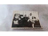 Fotografie Bărbați și femei în sufragerie cu aparat de radio retro