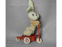 Vechiă jucărie mecanică metalică model scuter cu iepure