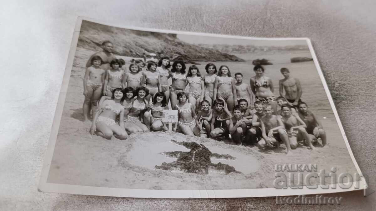 Fotografie cu bărbați, femei, băieți și fete pe plajă Fotografie cu bărbați, femei, băieți și fete pe plajă