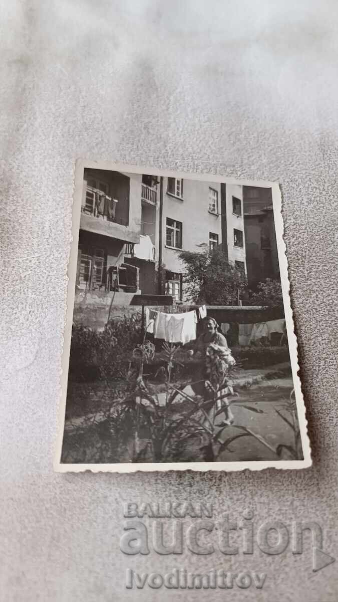 Fotografie Sofia Femeie întinzând rufe în curte Fotografie Sofia Femeie întinzând rufe în curte