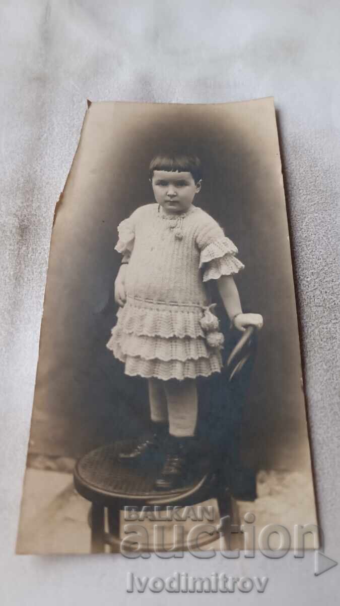 Fotografie Fetiță mică pe scaun de lemn