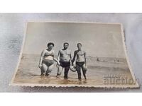 Photo Two men and a woman on the beach