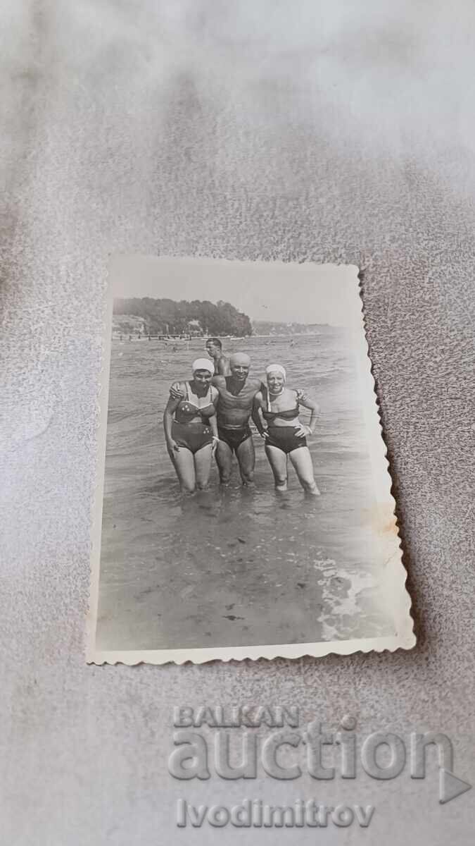 Φωτογραφία Ένας άντρας και δύο νεαρές γυναίκες στην παραλία