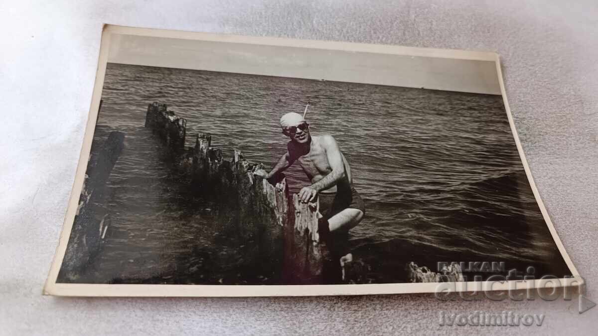 Φωτογραφία Άνδρα σε κατεστραμμένο ντόκο στη θάλασσα Φωτογραφία Άνδρα σε κατεστραμμένο ντόκο στη θάλασσα