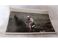 Fotografie cu un bărbat pe un ponton distrus în mare