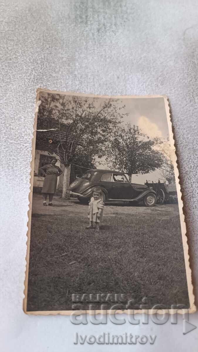 Снимка Жена и малко момиченце пред лек ретро автомобил