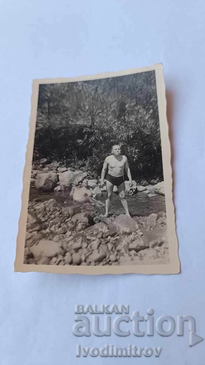 Photo of a Man in Swim Trunks in a Riverbed