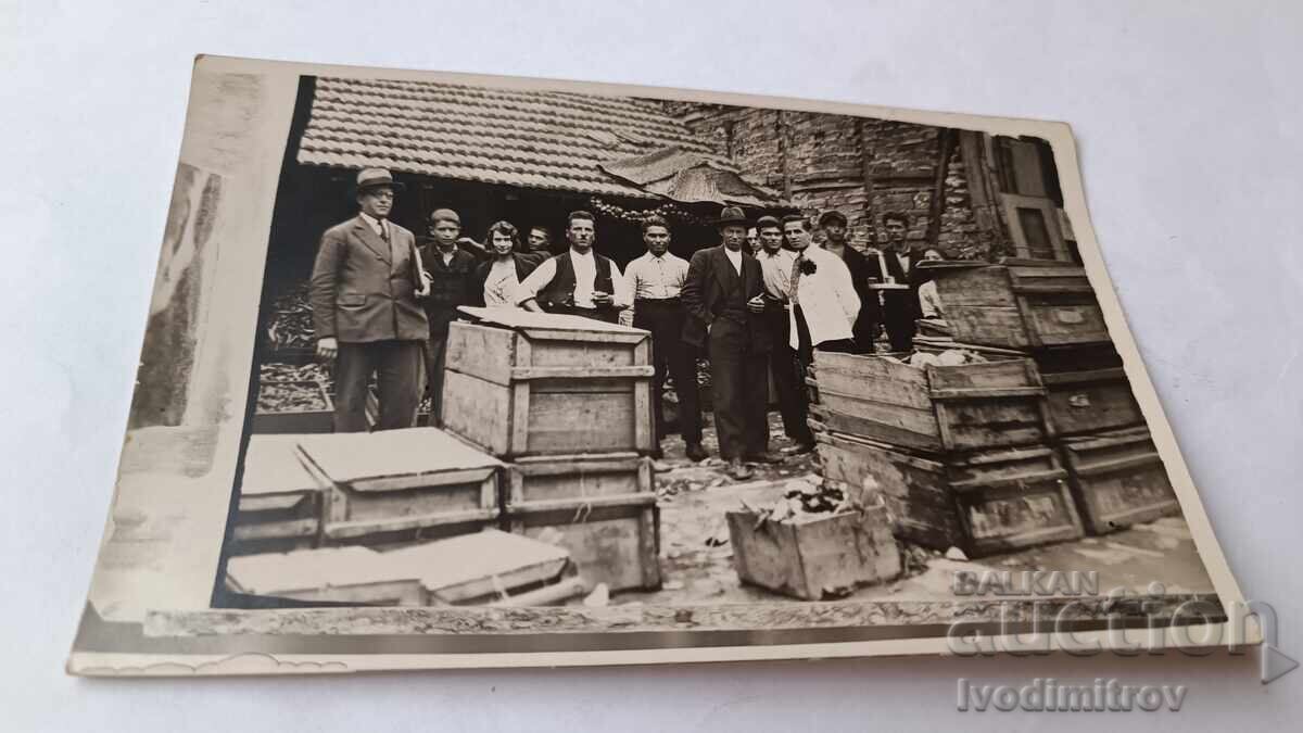 Fotografie Bărbați și fete tinere lângă lăzi pe stradă