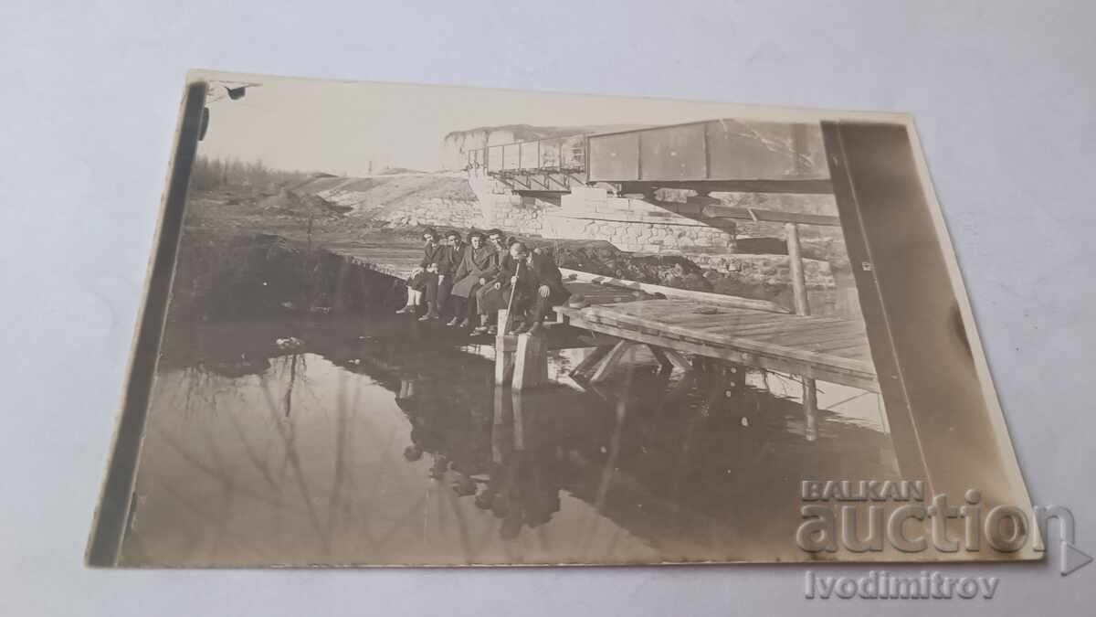 Photo of Young Men and a Young Woman on the Pier