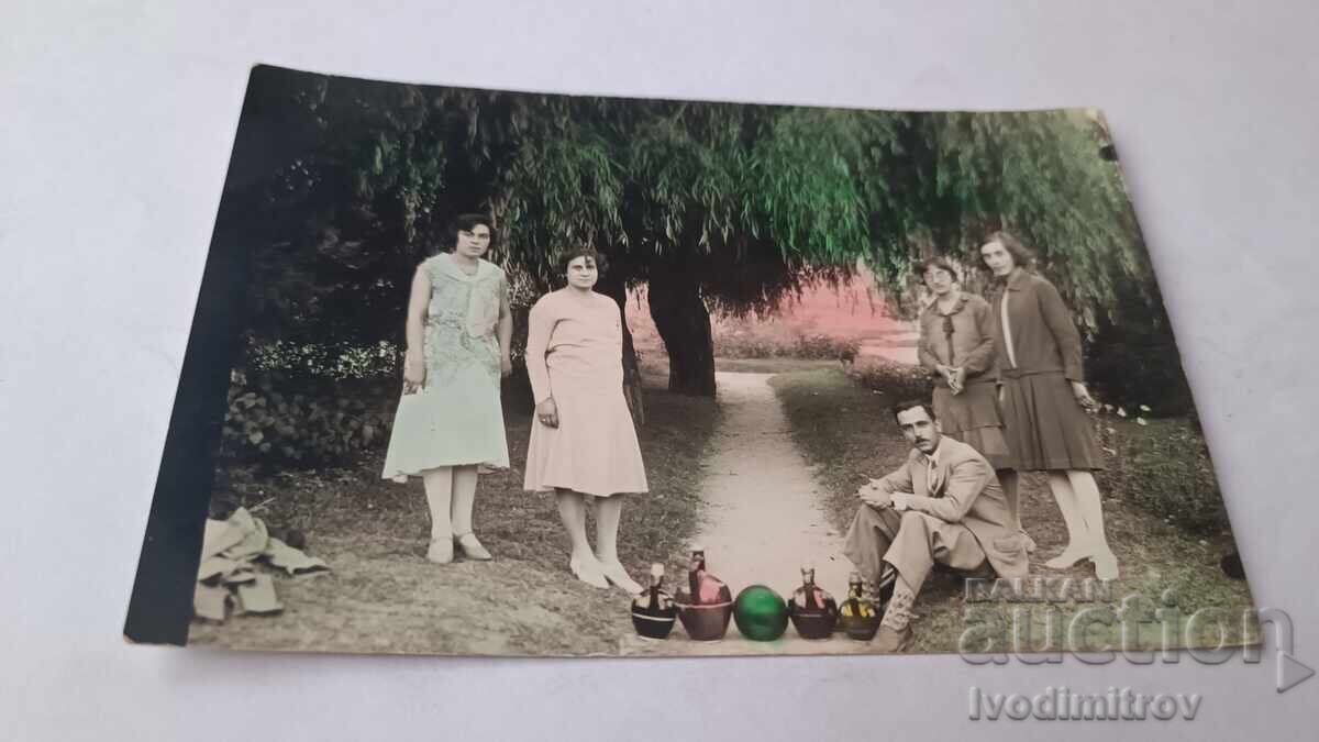 Photo of a man and four young girls on a path in the park