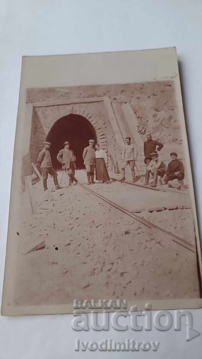 Fotografie Bărbați și femeie în fața unui tunel de cale ferată Fotografie Bărbați și femeie în fața unui tunel de cale ferată