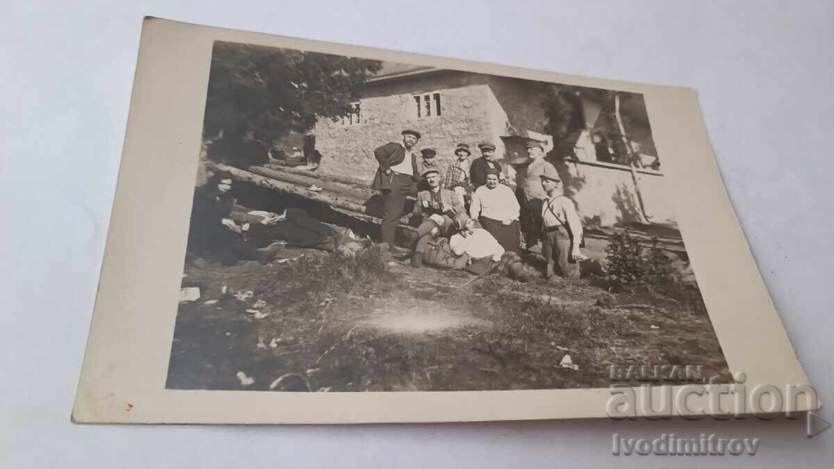 Fotografie Bărbați și copii în fața unei cabane la munte