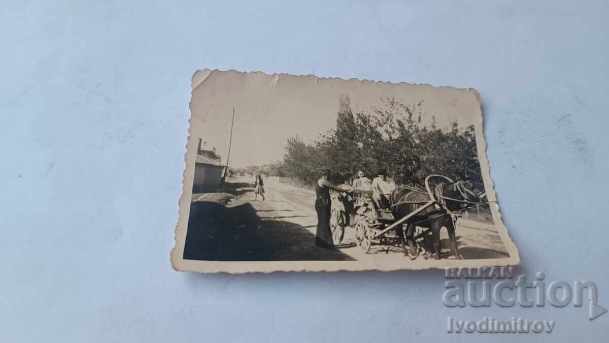 Photograph of two men and a young girl with a cart on the road