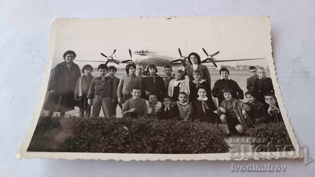 Снимка Жени и деца на пистата пред витлов пътнически самолет Снимка Жени и деца на пистата пред витлов пътнически самолет