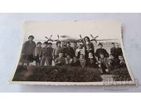 Φωτογραφία Γυναικών και παιδιών στην πίστα μπροστά από αεροπλάνο επιβατών με έλικες