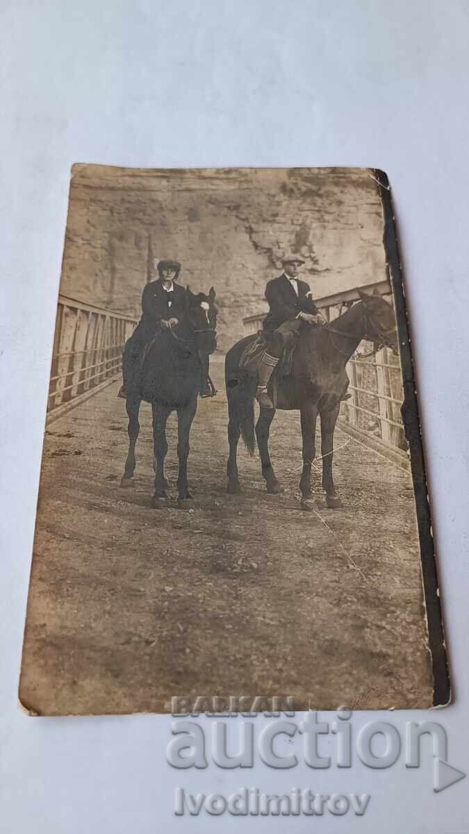 Снимка Мъж и младо момиче с коне на железен мост над река Снимка Мъж и младо момиче с коне на железен мост над река