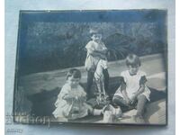Fotografie veche - trei copii mici, căluț, jucării