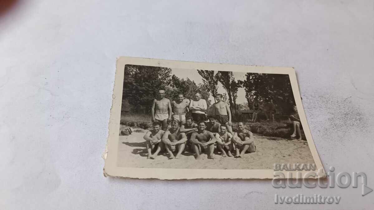 Foto Bărbați și tineri pe plajă