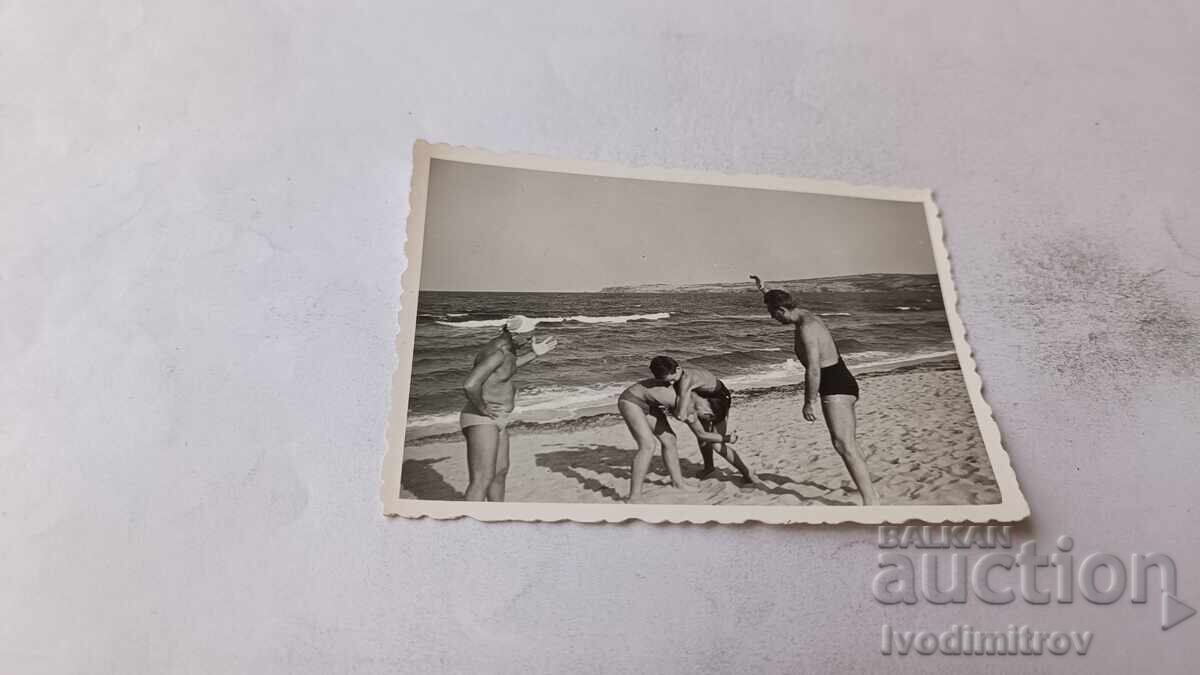 Foto Bărbați și tineri pe plajă
