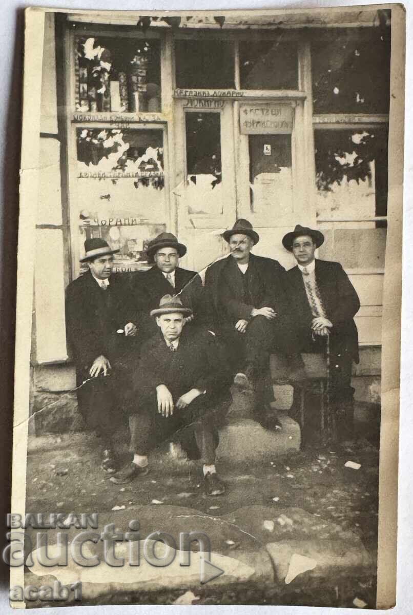 Bărbați în fața magazinului