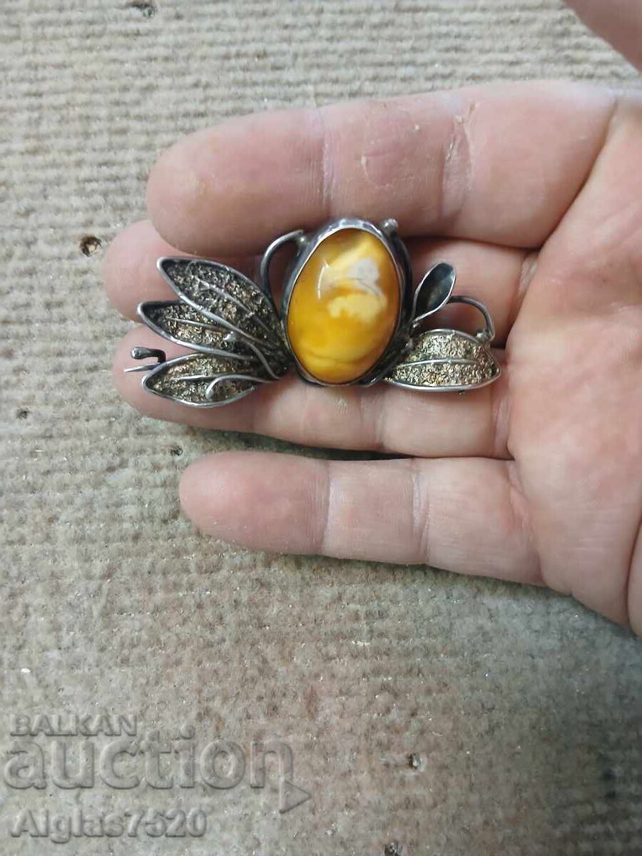 Old, worn, silver brooch with stone