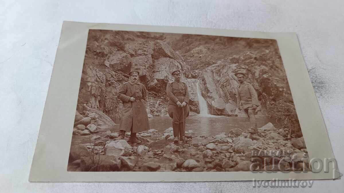 Photo Three officers in front of a small waterfall on the WWI front