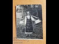 Fată în costum popular purtând o cobiliță cu donițe