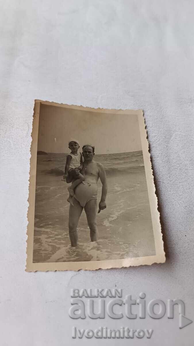 Imaginează Un bărbat și un băiețel pe plajă
