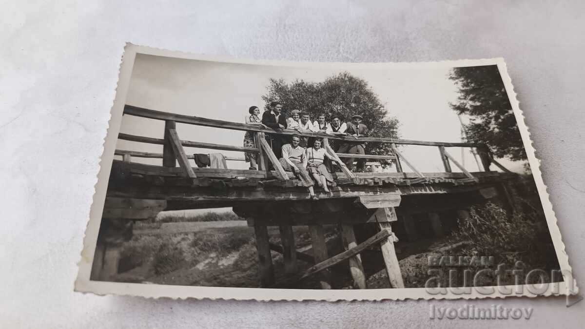 Fotografie tineri și tinere pe un pod de lemn