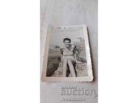 Fotografie: Tânăra femeie stă pe o stâncă lângă mare