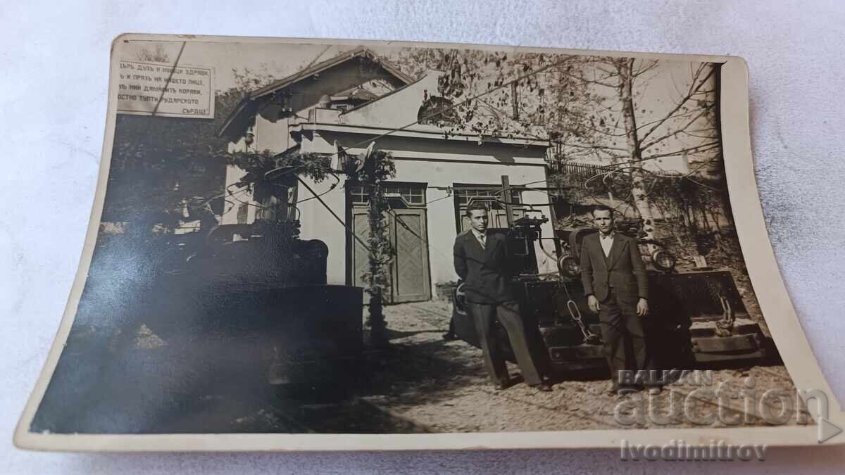 Fotografie Doi bărbați în fața unui atelier Fotografie Doi bărbați în fața unui atelier