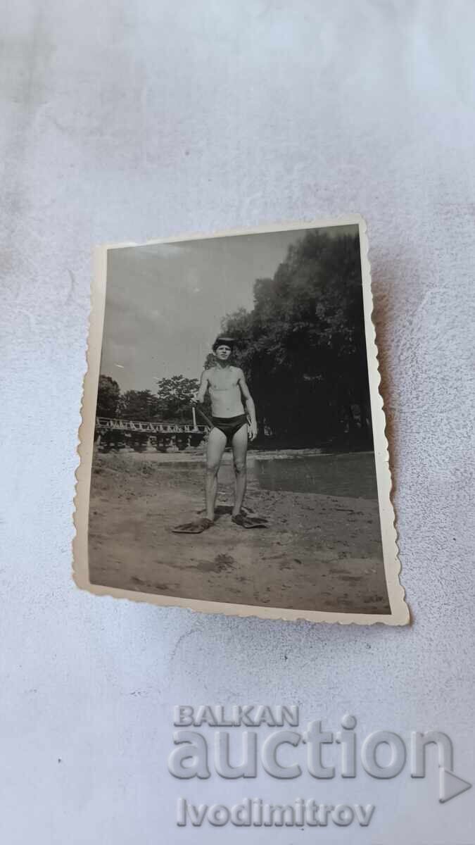 Fotografie Tânăr cu înotătoare pe lângă un râu