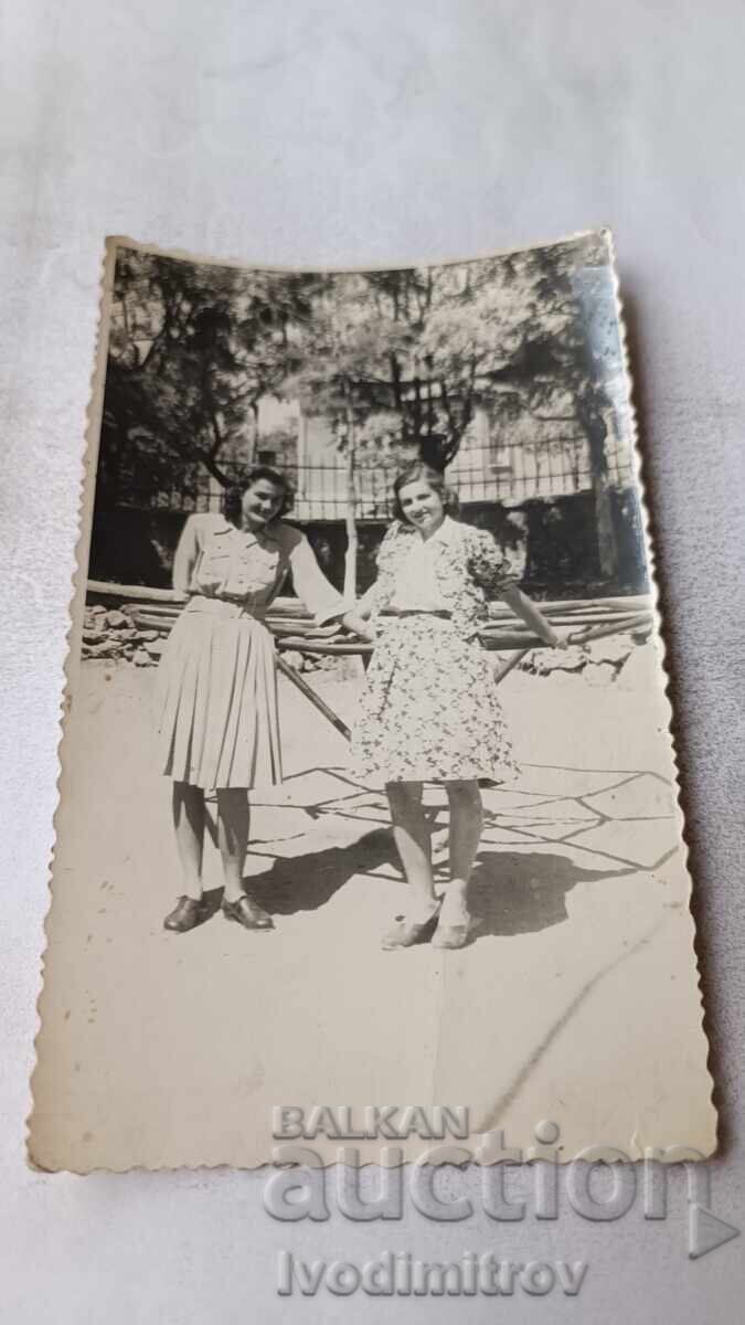 Φωτογραφία Σόφια Δύο νεαρά κορίτσια μπροστά από ένα καρουζέλ στο πάρκο