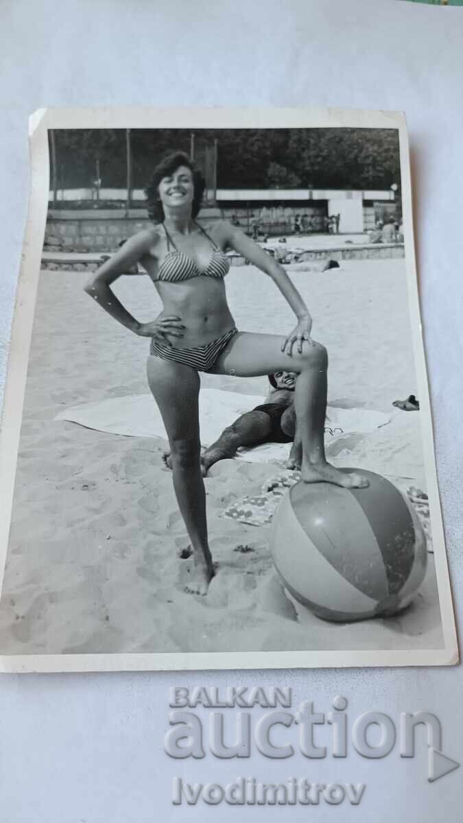 Fotografie Tânără femeie cu o minge gonflabilă pe plajă