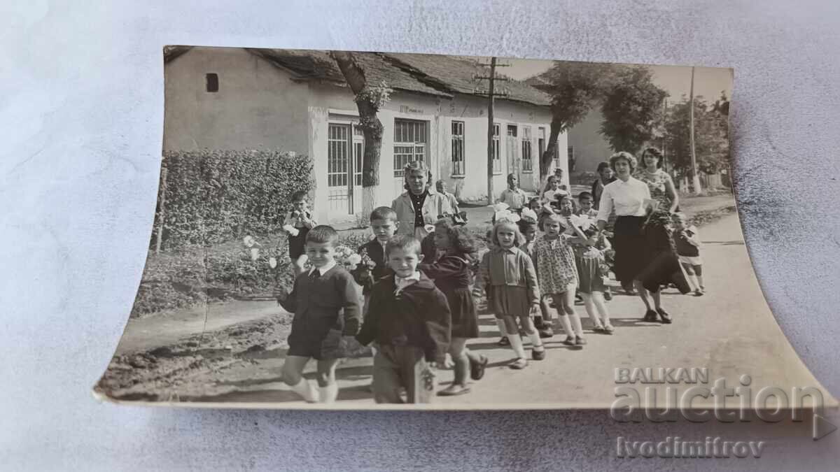 Fotografie copii și educatoare pe stradă