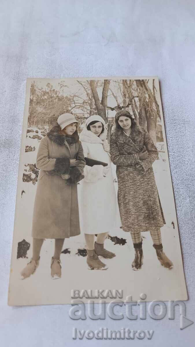 Photo Three young girls in winter coats in the park