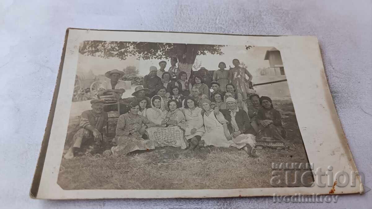 Снимка Мъже и жени седнали под дърво