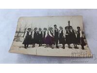 Φωτογραφία Άνδρας και νεαρές γυναίκες με παραδοσιακές ενδυμασίες τον χειμώνα