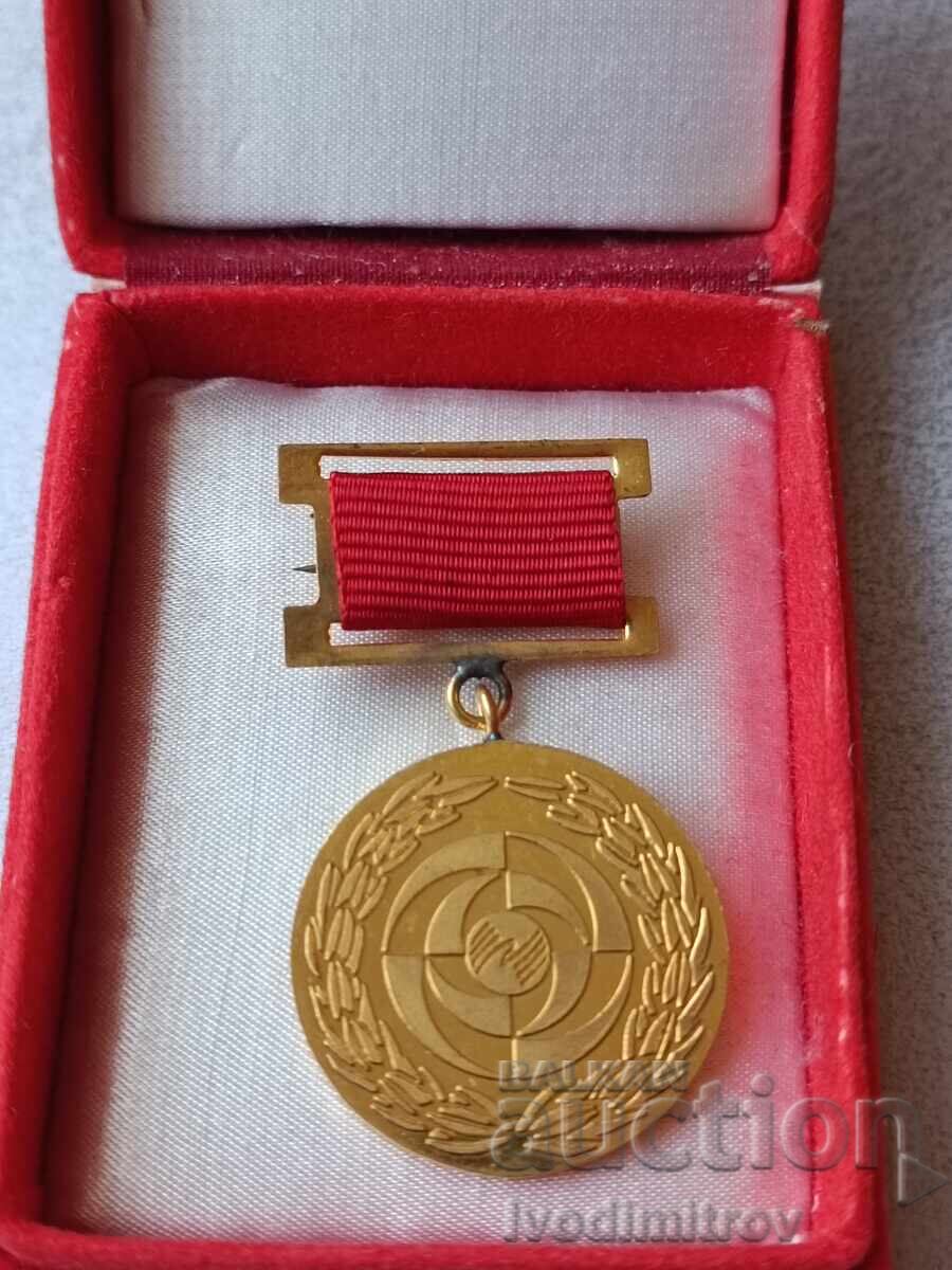 Insignă X revizuire națională jubiliară pentru contribuția la dezvoltarea TNTM