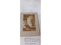 Fotografie Bărbat așezat pe un scaun în curtea unei case Carton