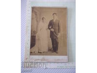 Fotografie veche pe carton cu un cuplu de miri într-un studio foto